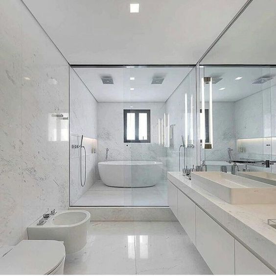 Banheiro com mármore branco no piso, nas paredes e na bancada