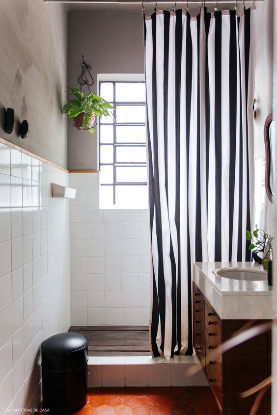 Banheiro com meia parede de azulejos brancos