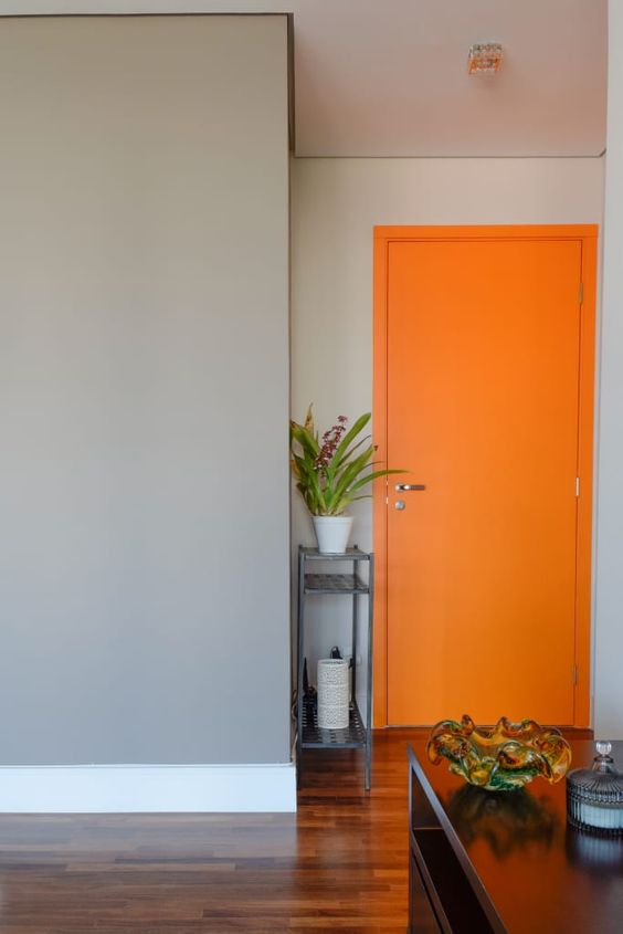 Cores: Porta de madeira pintada de laranja com parede cinza