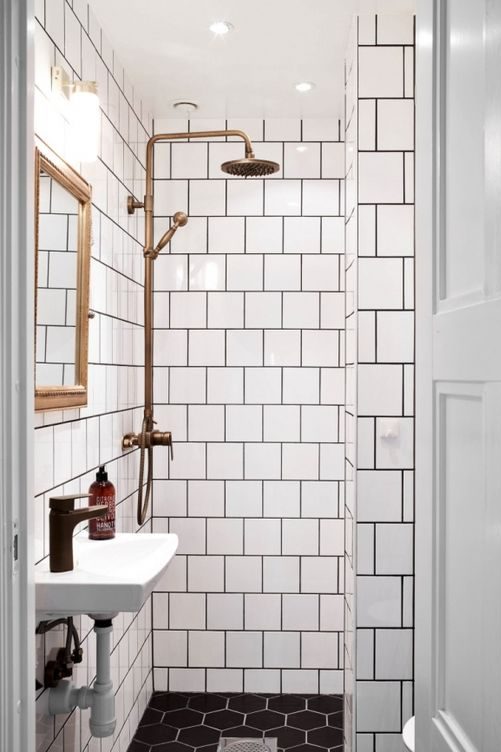 Banheiro com azulejo branco e rejunte preto e colocação tipo tijolinho